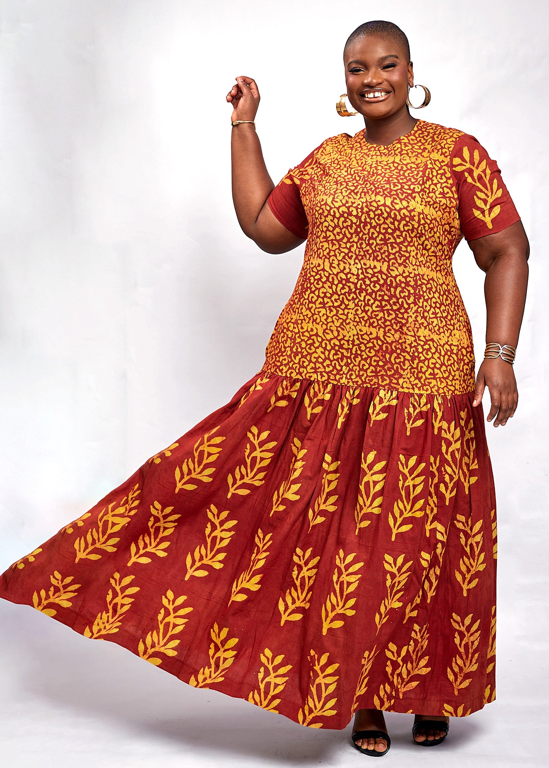 Woman wearing a red and yellow patterned outfit on a white background