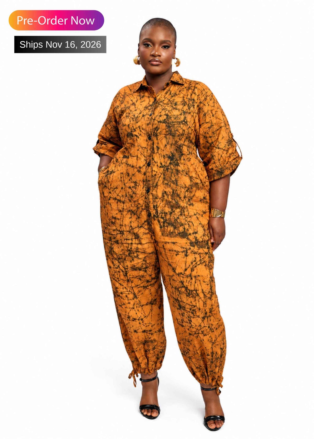 Woman wearing the orange Writing hand-dyed batik jumpsuit with balloon legs – African print cotton jumpsuit by Zanaani